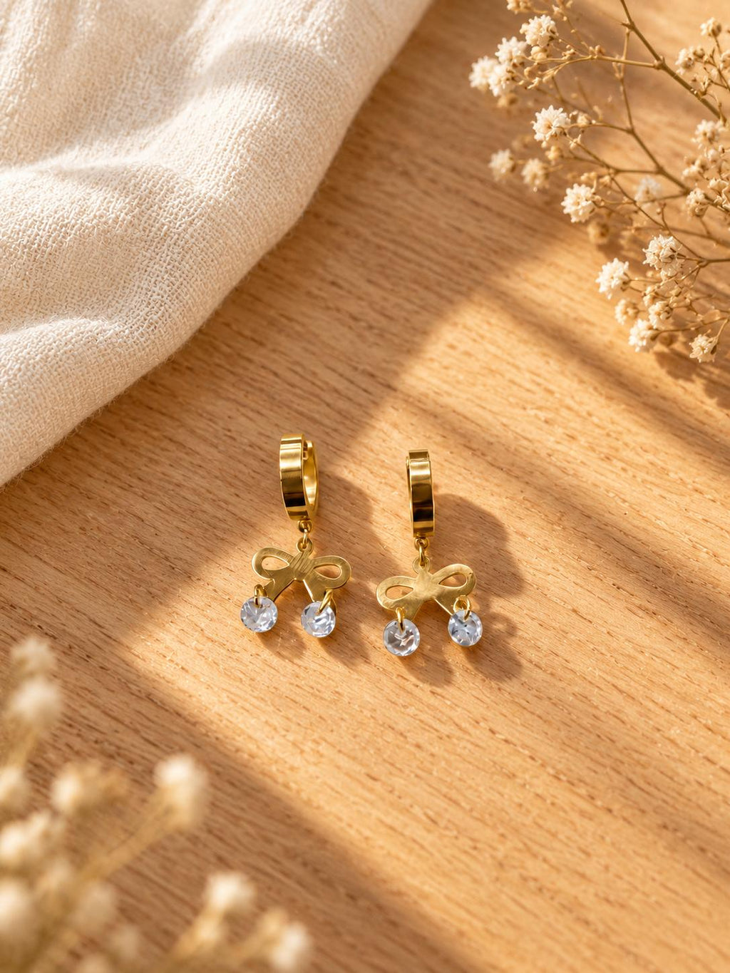 Aretes de aro dorados con moño y colgantes transparentes para mujer