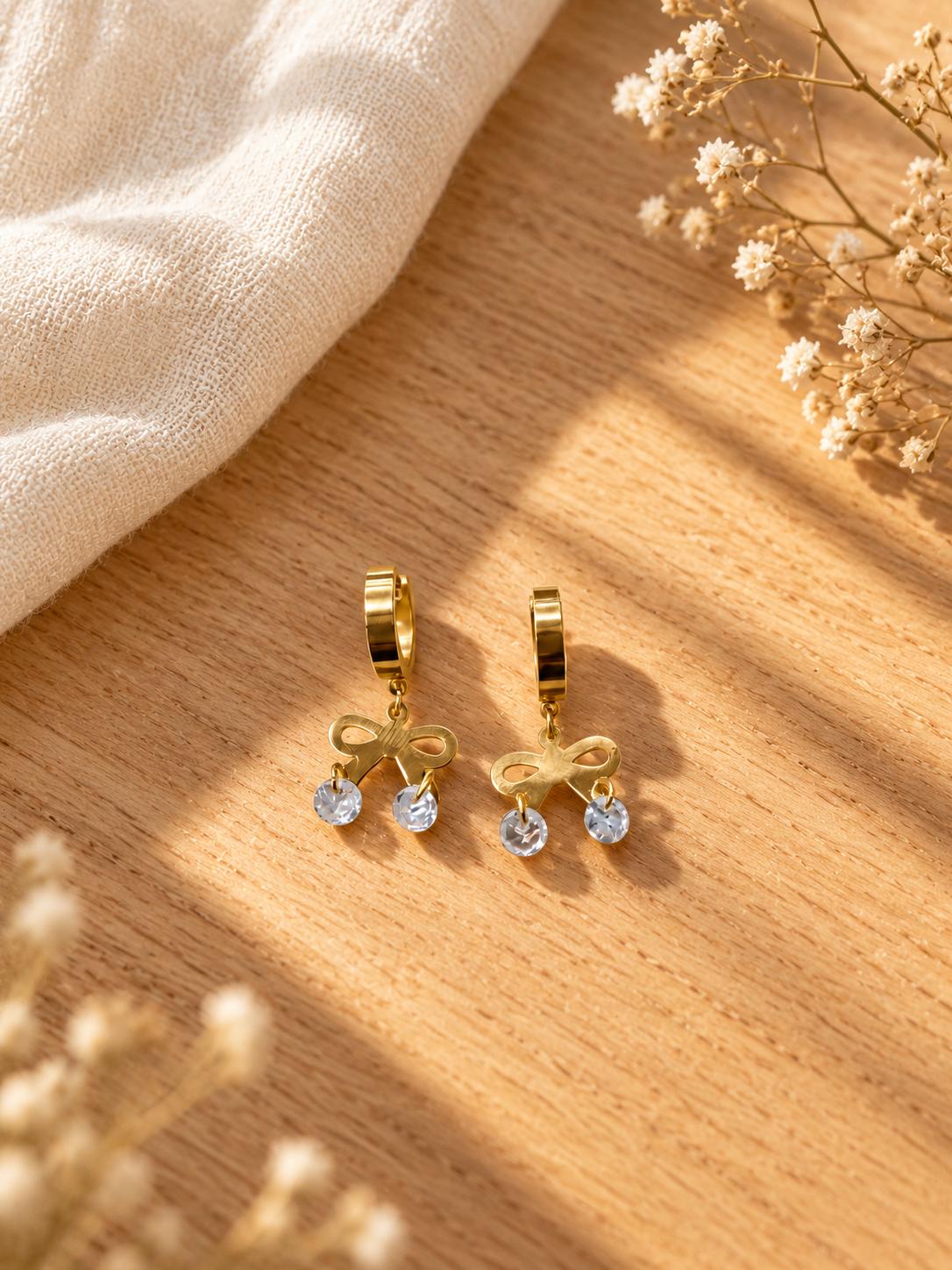 Aretes de aro dorados con moño y colgantes transparentes para mujer