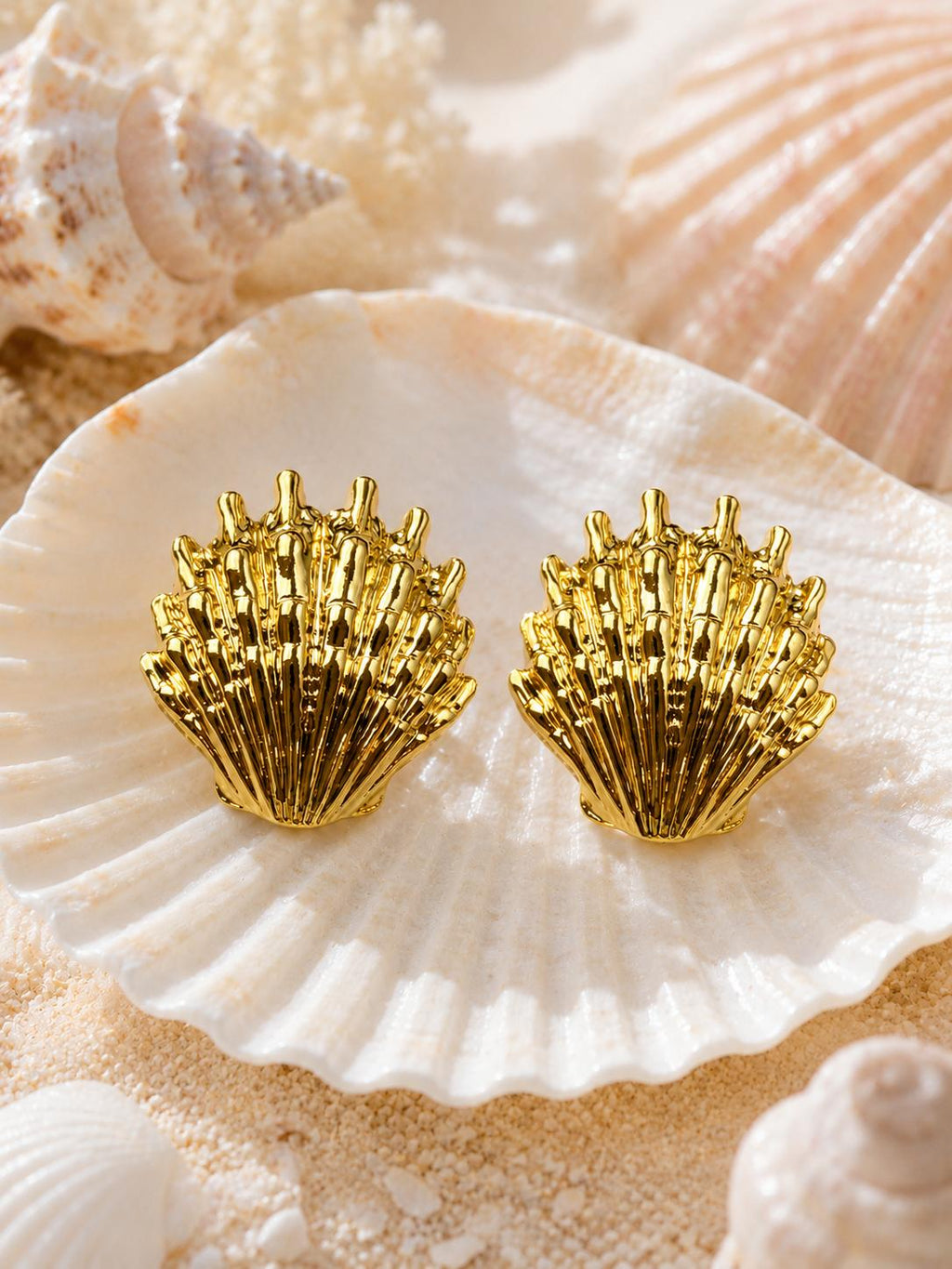 Aretes dorados en forma de concha marina con textura en relieve para mujer
