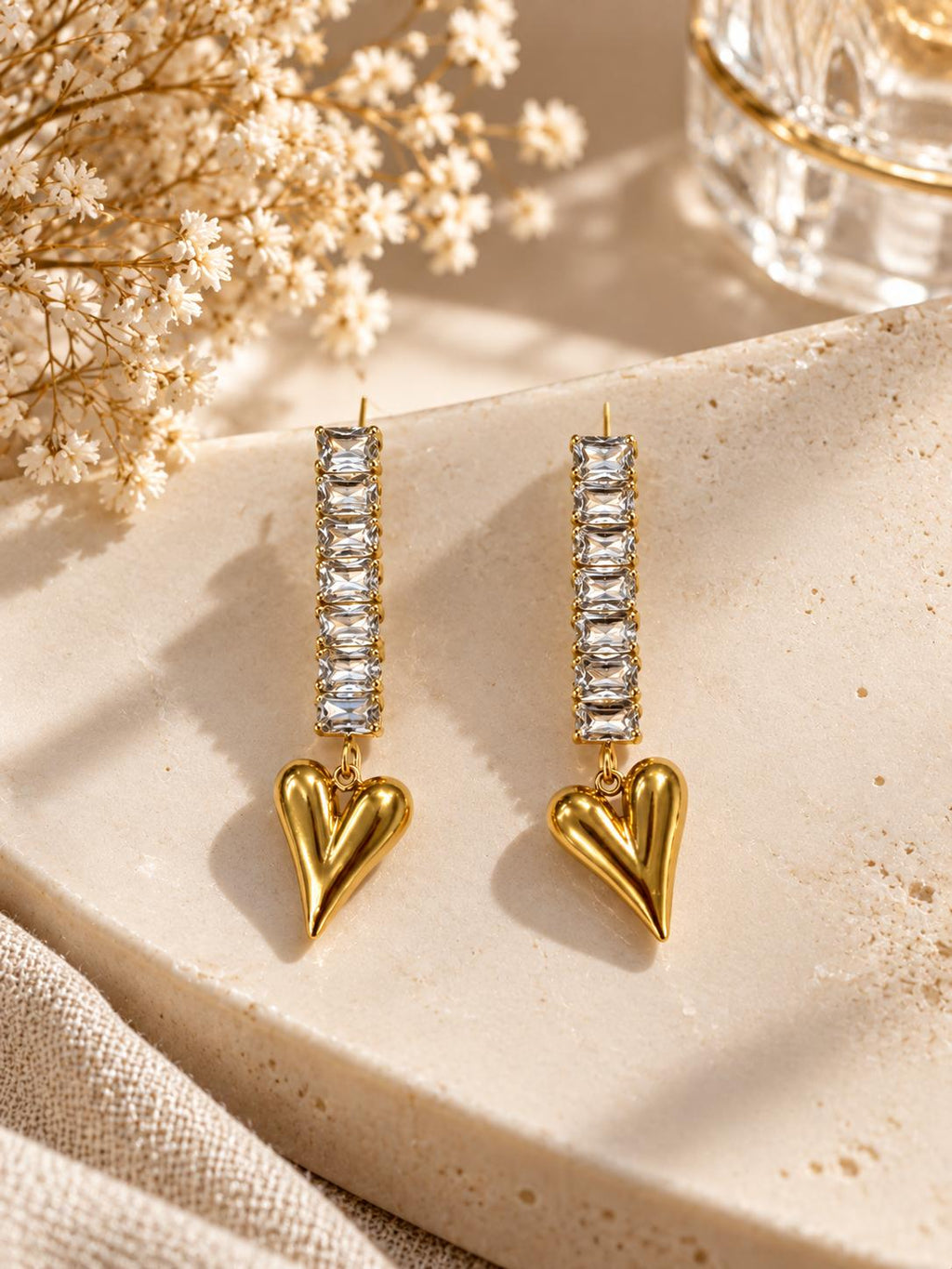 Aretes largos con piedras rectangulares y corazón colgante en tono dorado