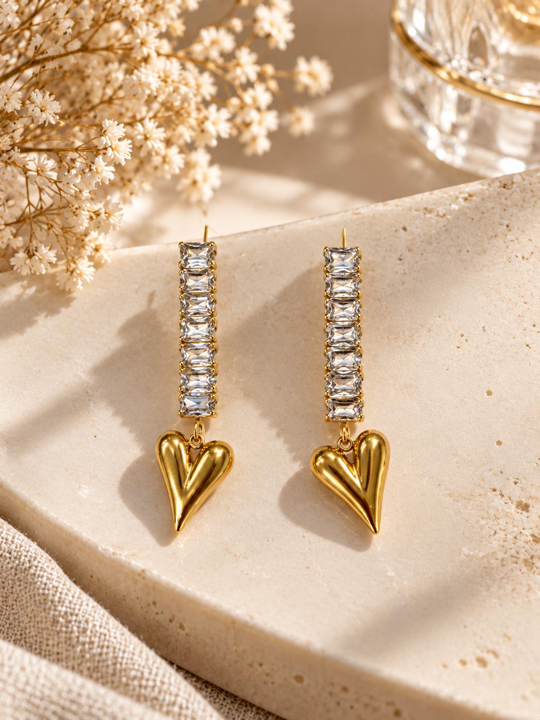 Aretes largos con piedras rectangulares y corazón colgante en tono dorado