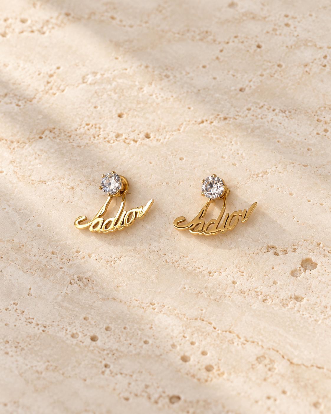 Aretes dorados con diseño de letras y piedra brillante redonda para mujer – 1 par