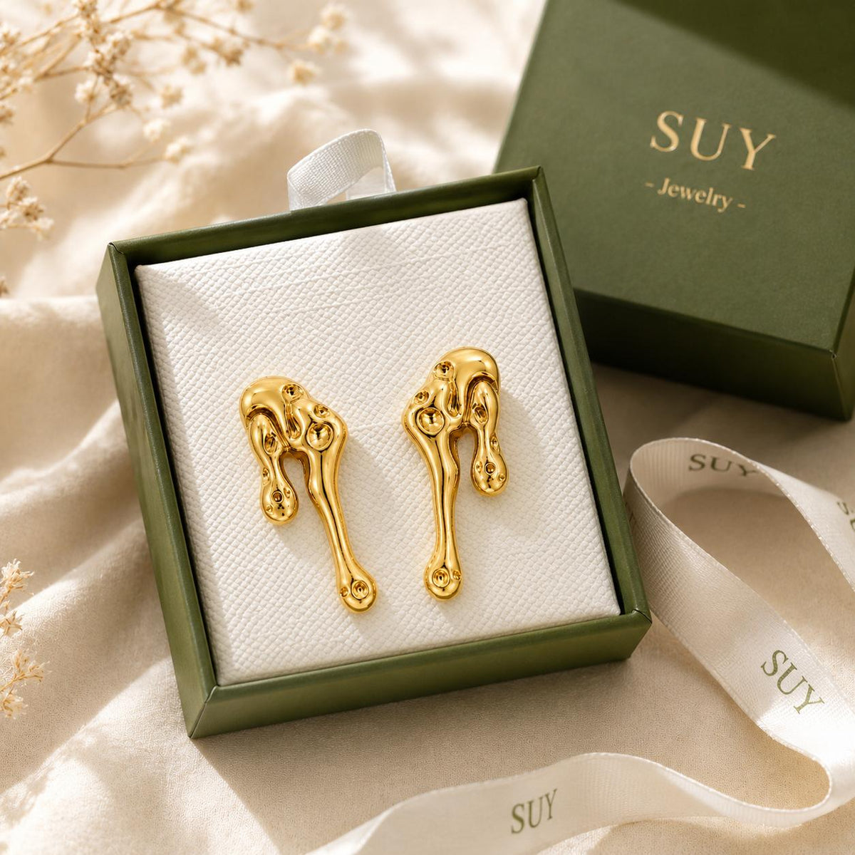 Aretes largos dorados de diseño abstracto con efecto metal líquido para mujer